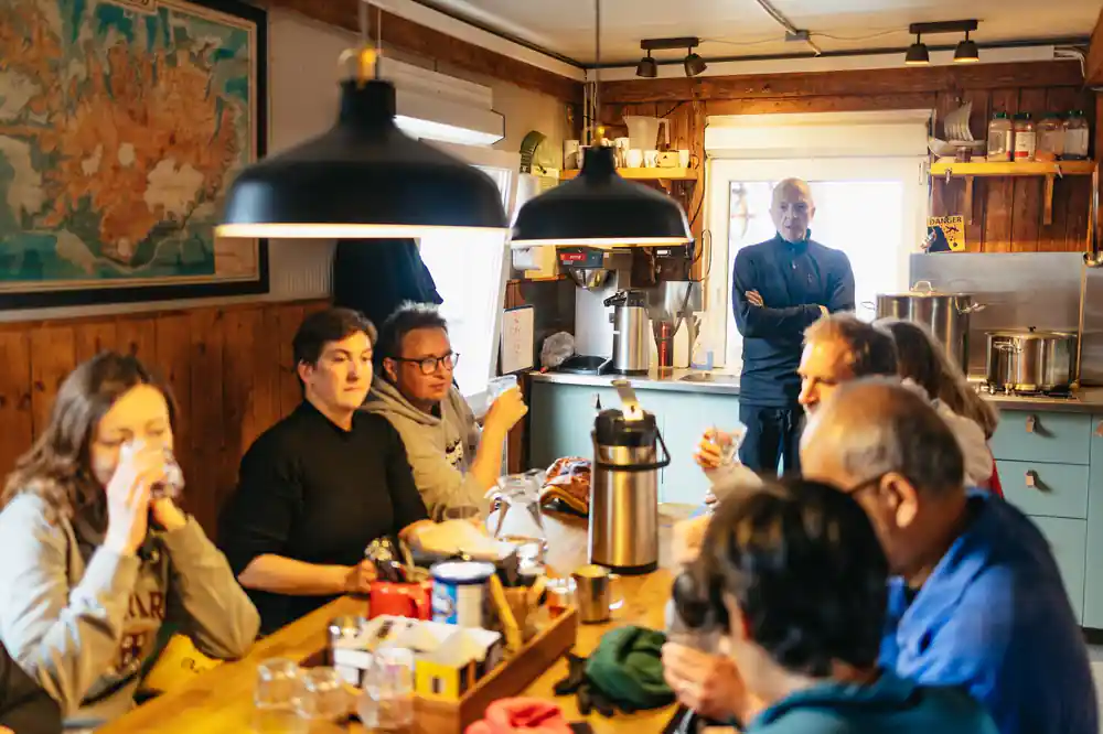 The cabin interior with the group at the table after the walk