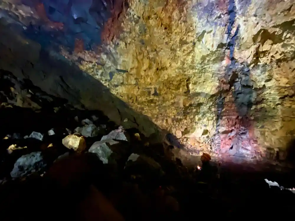 The chamber wall above the boulder floor, gold over dark basalt