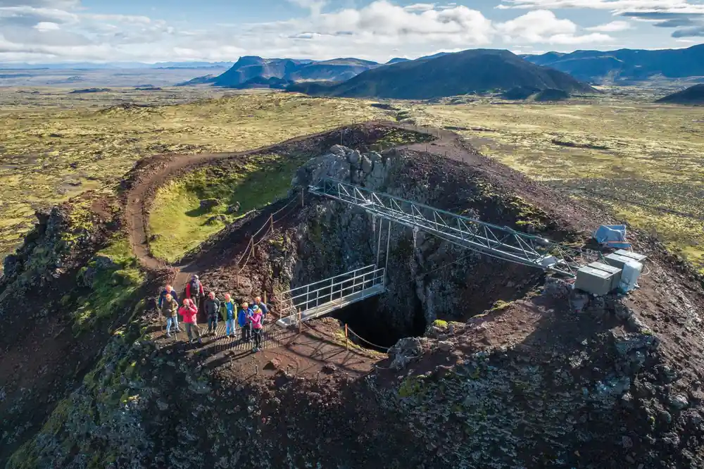 The crater opening from above with the steel gantry across it and the group waiting