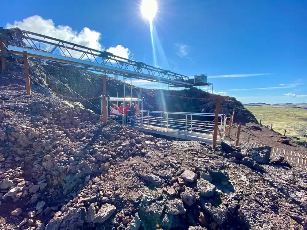 The gantry over the crater against a bright sky with the platform below