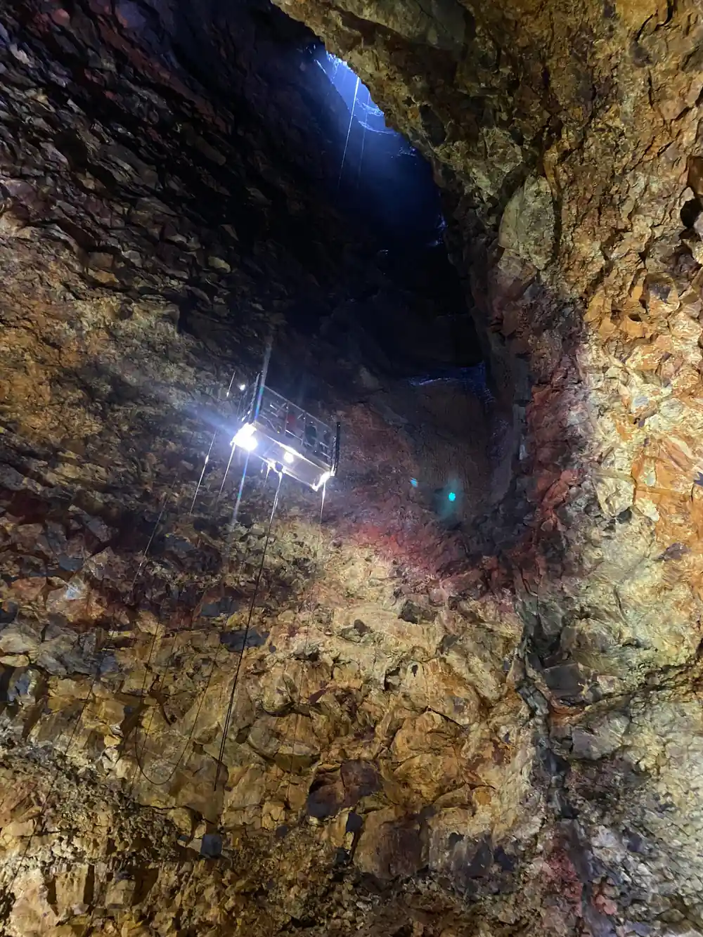 Lamps strung across the chamber wall in the dark