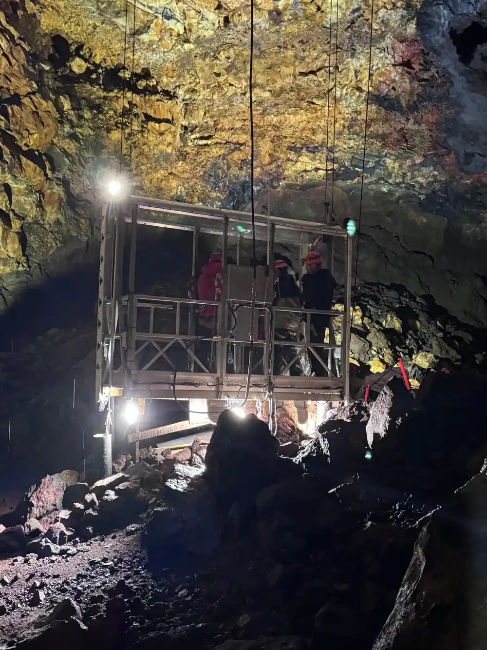 The open lift platform inside the chamber, lit, with people aboard