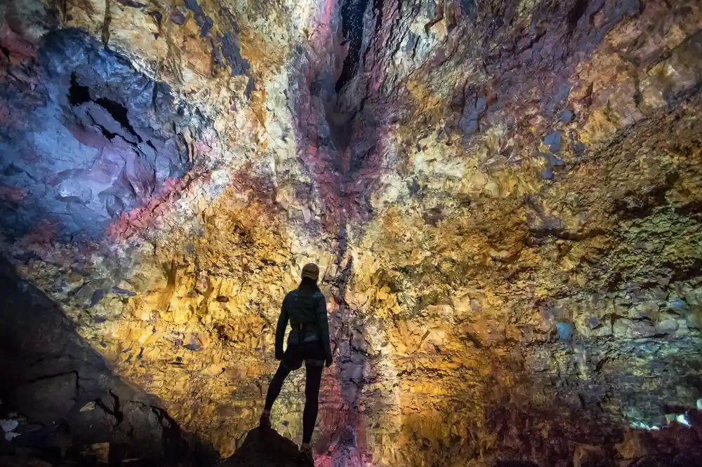 A single figure on the chamber floor, dwarfed by the shaft above