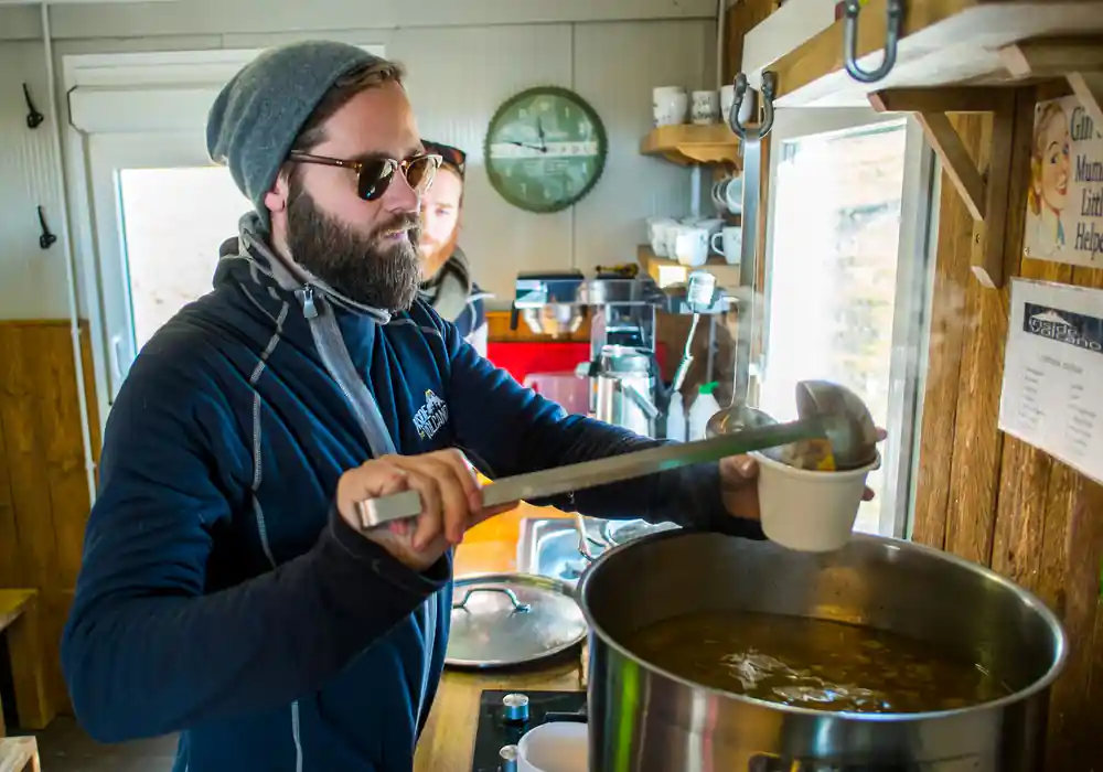 Soup being ladled from the pot in the cabin kitchen