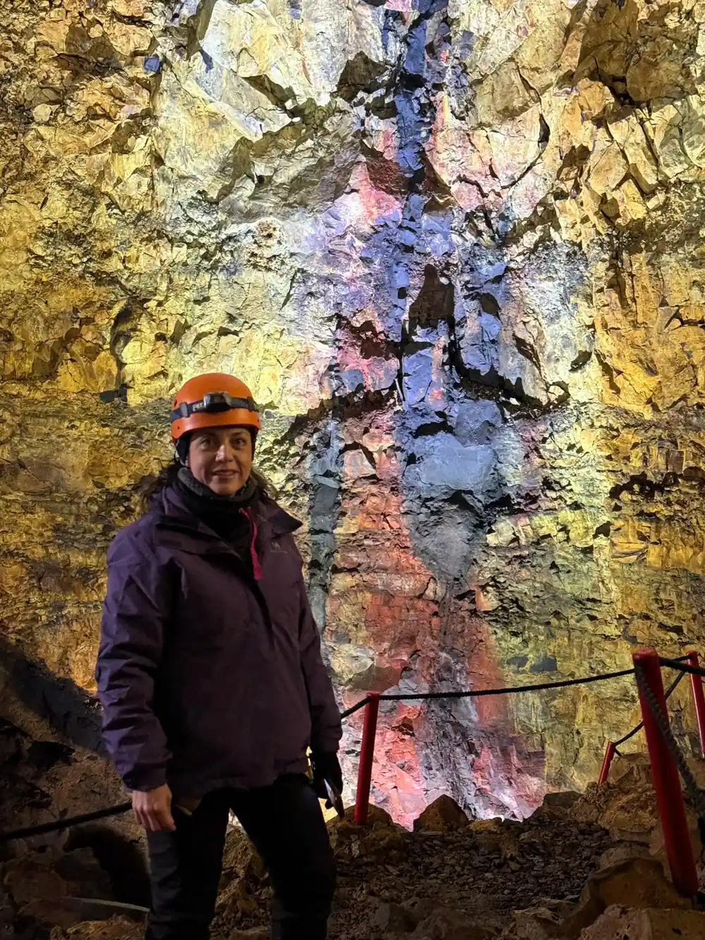 A visitor in a helmet against the red and yellow chamber wall