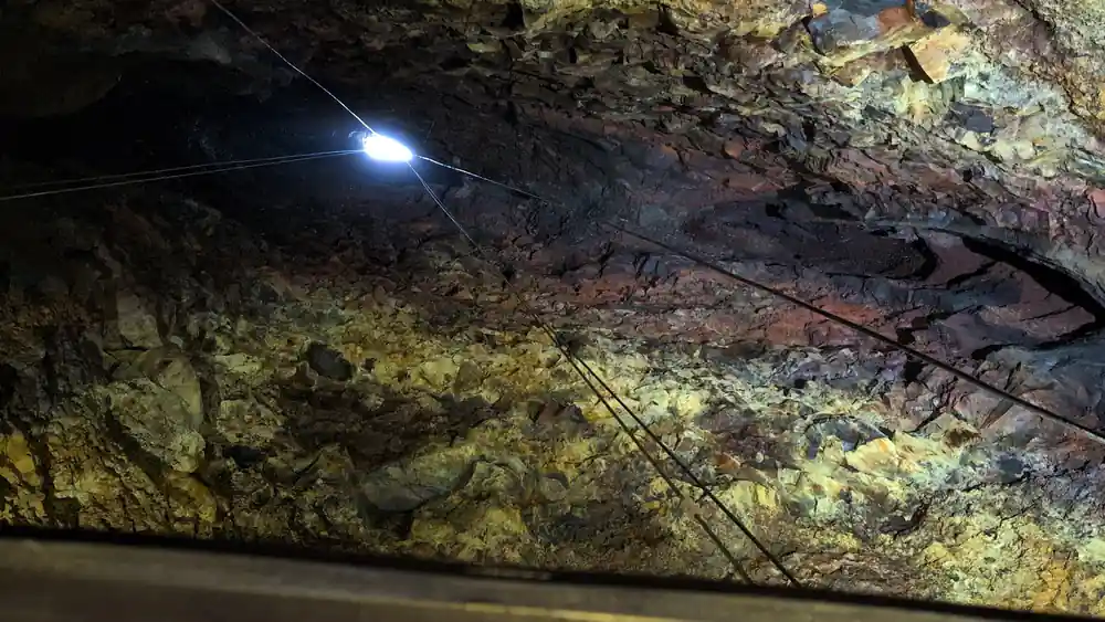 Wires and a lamp across the rough chamber ceiling